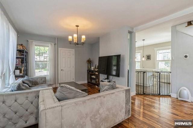 129 Phelps Ave, Englewood, NJ 07631 - living room with wood finished floors, a chandelier, and baseboards