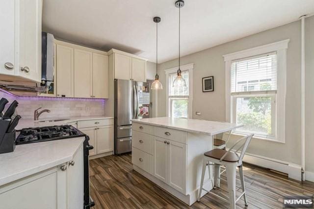 129 Phelps Ave, Englewood, NJ 07631 - kitchen featuring stainless steel appliances, a sink, dark wood-type flooring, backsplash, and light countertops