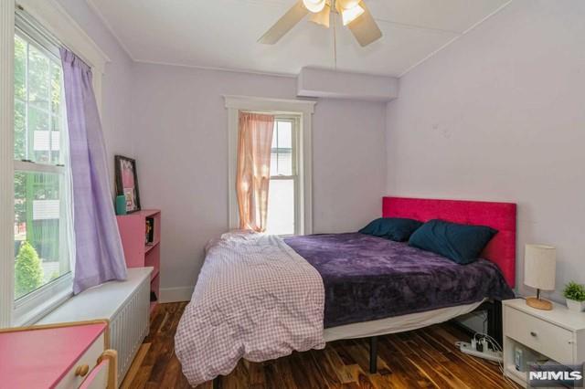 129 Phelps Ave, Englewood, NJ 07631 - bedroom featuring multiple windows, wood finished floors, and ceiling fan