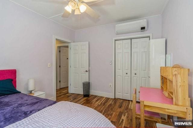 129 Phelps Ave, Englewood, NJ 07631 - bedroom featuring a wall mounted AC, wood finished floors, baseboards, a closet, and ceiling fan