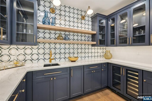 107 Rutland Rd, Glen Rock, NJ 07452 - bar with beverage cooler, tasteful backsplash, and light wood finished floors