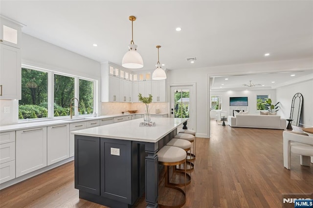 107 Rutland Rd, Glen Rock, NJ 07452 - kitchen featuring a sink, tasteful backsplash, white cabinetry, open floor plan, and a kitchen island