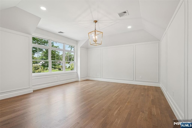 107 Rutland Rd, Glen Rock, NJ 07452 - unfurnished dining area featuring a decorative wall, a chandelier, vaulted ceiling, wood finished floors, and recessed lighting