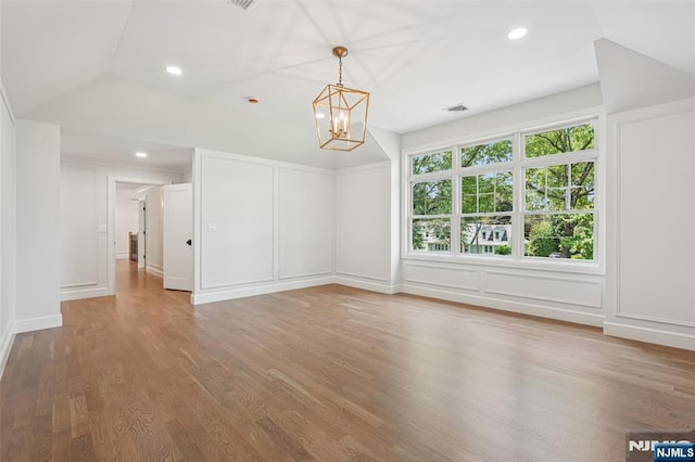 107 Rutland Rd, Glen Rock, NJ 07452 - spare room with vaulted ceiling, a decorative wall, a chandelier, wood finished floors, and recessed lighting