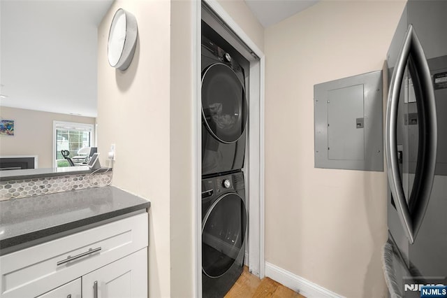 32 Mallard Ct, Englewood, NJ 07631 - laundry area with stacked washing machine and dryer, electric panel, light wood-style floors, and baseboards
