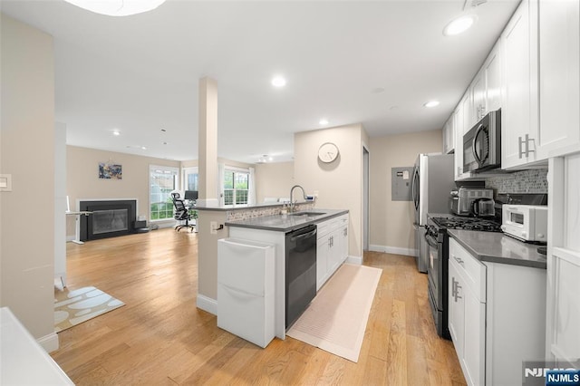 32 Mallard Ct, Englewood, NJ 07631 - kitchen with dishwasher, stainless steel gas range oven, dark countertops, white microwave, and white cabinetry