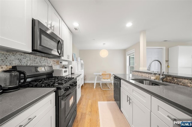 32 Mallard Ct, Englewood, NJ 07631 - kitchen featuring black appliances, a sink, dark countertops, light wood-type flooring, and recessed lighting