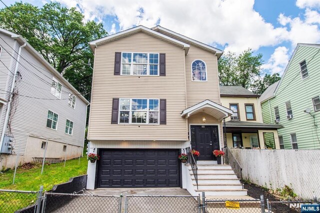 167 5th St, Paterson, NJ 07522 - view of front facade featuring a fenced front yard, a gate, an attached garage, and driveway