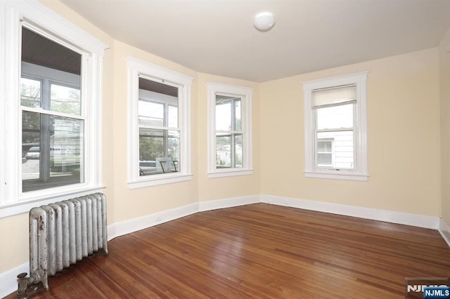 267 Hoover Ave, Bloomfield, NJ 07003 - unfurnished room with radiator, dark wood-style floors, and baseboards