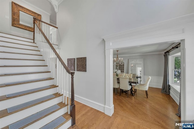 43 Heights Rd, Allendale, NJ 07401 - staircase with ornamental molding, wood finished floors, a chandelier, and wainscoting