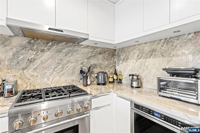320 Adolphus Ave Unit 702, Cliffside Park, NJ 07010 - kitchen featuring gas range, under cabinet range hood, backsplash, white cabinetry, and oven