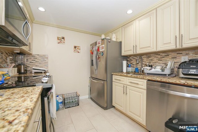 8841 Kennedy Unit 19, North Bergen, NJ 07047 - kitchen with appliances with stainless steel finishes, cream cabinets, backsplash, light tile patterned floors, and crown molding