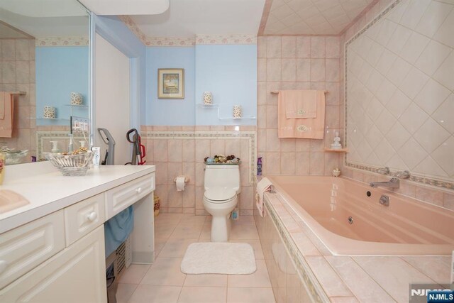 8841 Kennedy Unit 19, North Bergen, NJ 07047 - full bath featuring tile walls, a jetted tub, vanity, and tile patterned floors