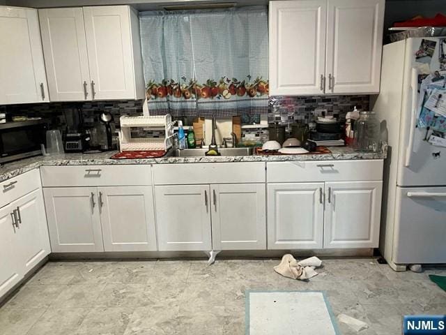 272 E Midland Ave, Garfield, NJ 07652 - kitchen featuring freestanding refrigerator, white cabinets, stainless steel microwave, tasteful backsplash, and light stone countertops