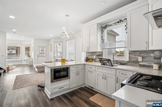 31 Vanderbeck Pl, Hackensack, NJ 07601 - kitchen featuring healthy amount of natural light, a peninsula, recessed lighting, white cabinets, and backsplash