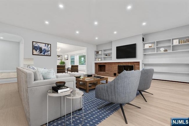 310 Spring Valley Rd, Paramus, NJ 07652 - living area featuring wood finished floors, recessed lighting, a brick fireplace, arched walkways, and built in features