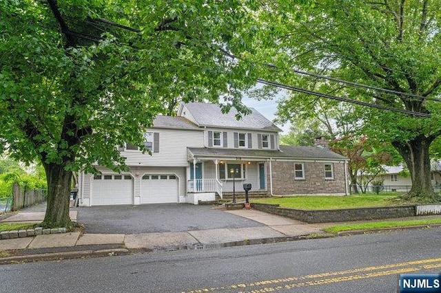 310 Spring Valley Rd, Paramus, NJ 07652 - traditional home with a garage, asphalt driveway, and a porch