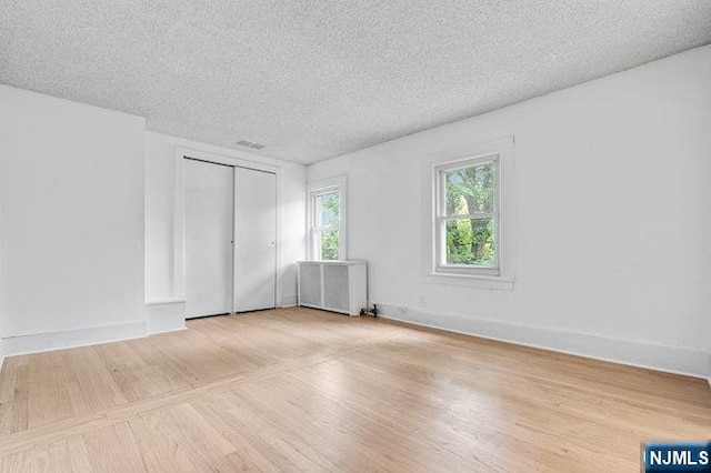 310 Spring Valley Rd, Paramus, NJ 07652 - unfurnished room with a textured ceiling, wood finished floors, radiator, and baseboards