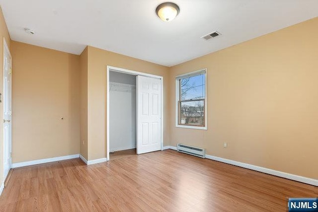 310 Spring Valley Rd, Paramus, NJ 07652 - unfurnished bedroom featuring baseboard heating, light wood-style floors, a closet, and baseboards