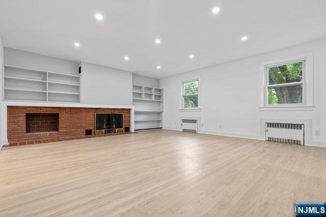 310 Spring Valley Rd, Paramus, NJ 07652 - unfurnished living room with a brick fireplace, radiator heating unit, light wood-style floors, and recessed lighting