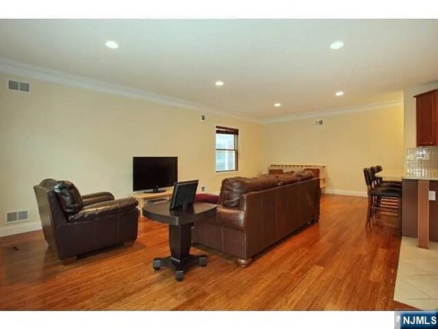 1128 43rd St Unit 1, North Bergen, NJ 07047 - living area featuring baseboards, ornamental molding, light wood finished floors, and recessed lighting