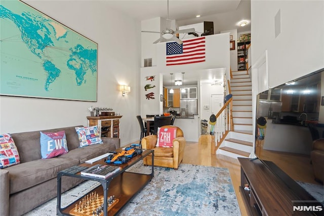 24 Ave At Port Imperial Unit 416, West New York, NJ 07093 - living room with stairs, ceiling fan, a towering ceiling, and wood finished floors