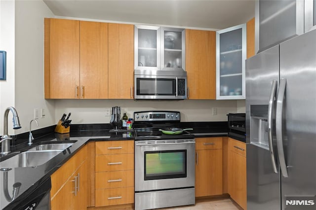 24 Ave At Port Imperial Unit 416, West New York, NJ 07093 - kitchen with appliances with stainless steel finishes, a sink, dark stone countertops, and glass insert cabinets