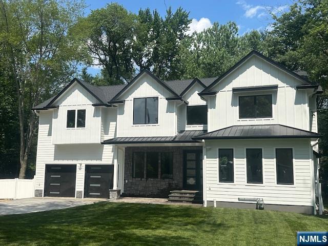 142 Ellsworth Ter, Glen Rock, NJ 07452 - view of front of house with a standing seam roof, a garage, concrete driveway, and board and batten siding