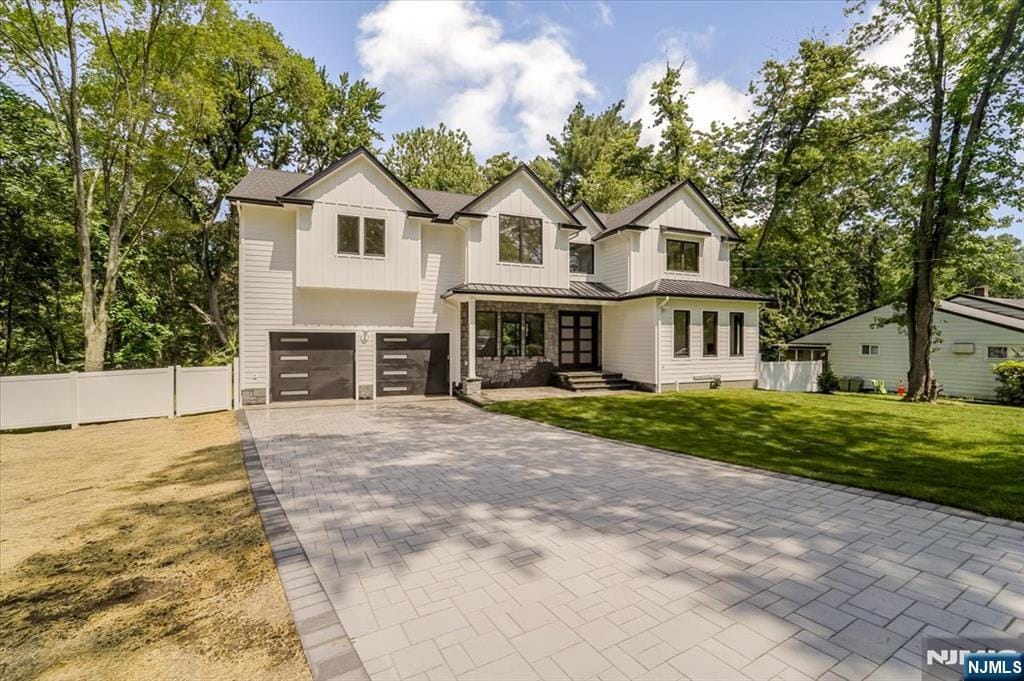 142 Ellsworth Ter, Glen Rock, NJ 07452 - modern farmhouse with an attached garage, decorative driveway, board and batten siding, and a metal roof