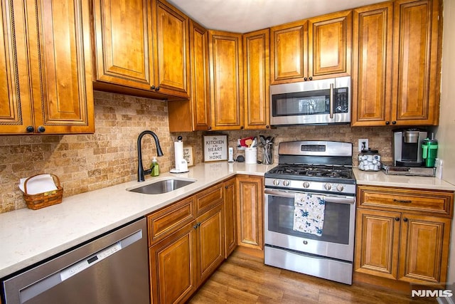 125 Virginia Ave, Dumont, NJ 07628 - kitchen featuring stainless steel appliances, a sink, brown cabinets, and light countertops