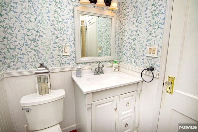 125 Virginia Ave, Dumont, NJ 07628 - bathroom featuring wallpapered walls, vanity, toilet, and wainscoting