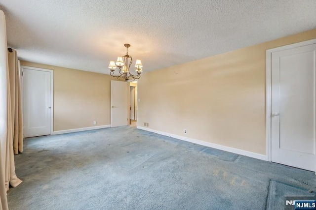 277 Jefferson Ave, Cresskill, NJ 07626 - carpeted spare room with a chandelier, baseboards, and a textured ceiling