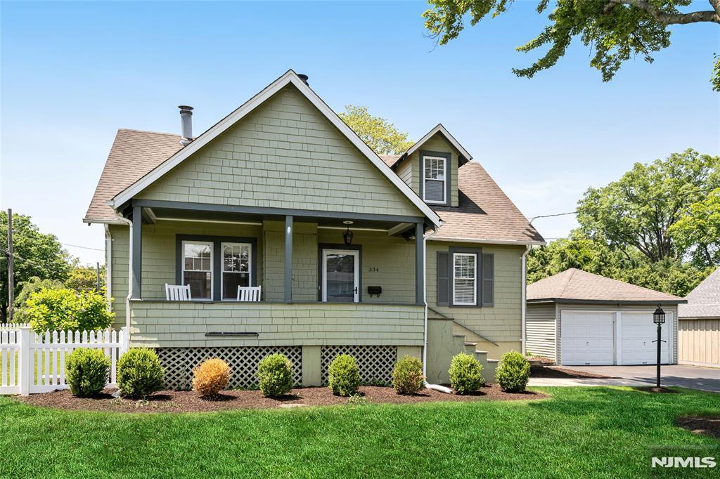 334 Corona Pl, Ridgewood, NJ 07450 - view of front of house featuring covered porch, a detached garage, a shingled roof, and an outdoor structure