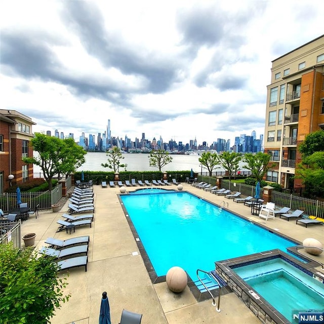 26 Ave At Port Imperial Unit 210, West New York, NJ 07093 - view of pool with a view of skyline, a patio, and a pool with connected hot tub