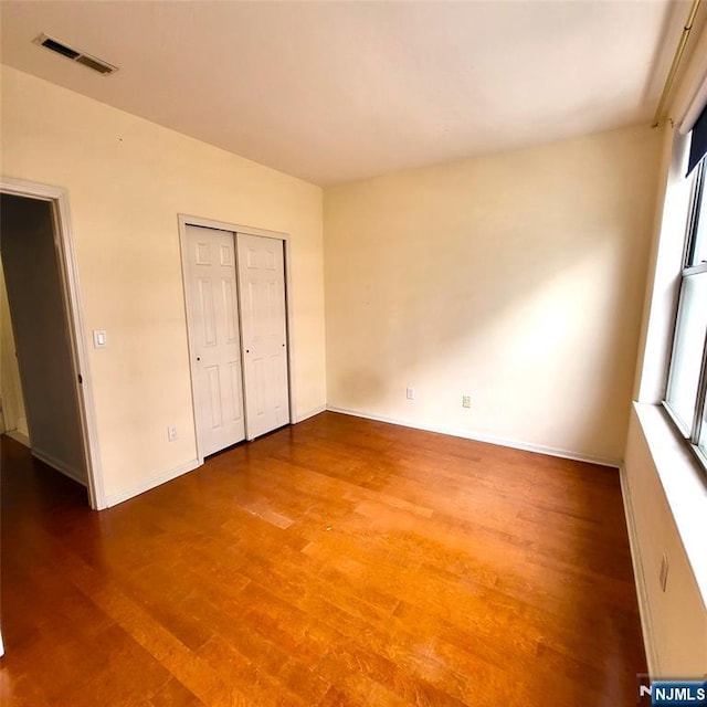 26 Ave At Port Imperial Unit 210, West New York, NJ 07093 - unfurnished bedroom with wood finished floors, baseboards, and a closet