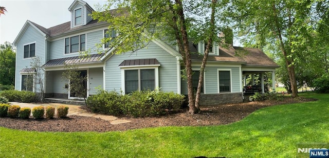 65 1st St, Allendale, NJ 07401 - view of front of home featuring a front yard, a standing seam roof, metal roof, stone siding, and a porch