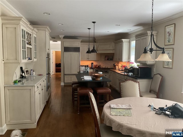 65 1st St, Allendale, NJ 07401 - kitchen featuring a kitchen island, dark wood-style flooring, crown molding, a sink, and glass insert cabinets