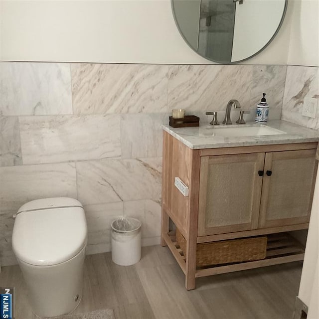 65 1st St, Allendale, NJ 07401 - bathroom featuring tile walls, wood finished floors, vanity, and toilet