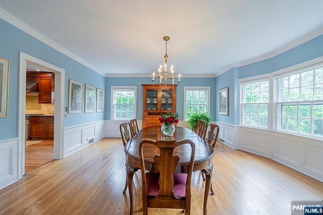 466 Park St, Montclair, NJ 07043 - dining area featuring a chandelier, a decorative wall, light wood-type flooring, a wainscoted wall, and ornamental molding
