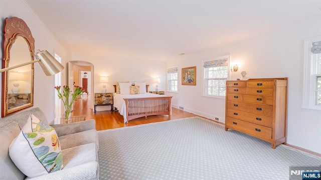 466 Park St, Montclair, NJ 07043 - bedroom featuring multiple windows, arched walkways, baseboards, and light wood-style flooring