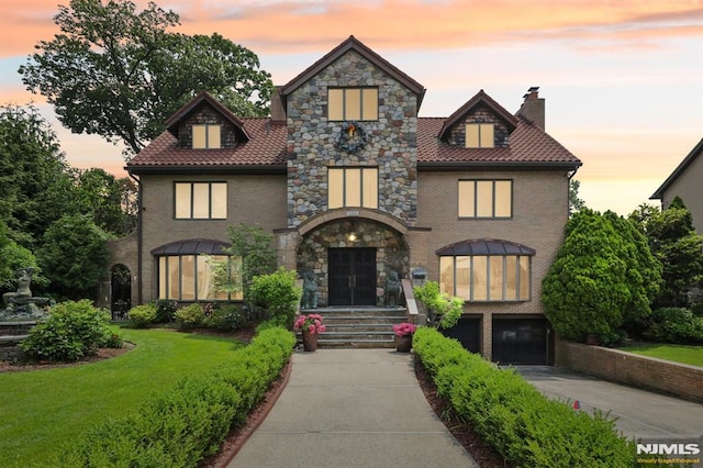 1060 Briar Way, Fort Lee, NJ 07024 - view of front facade with concrete driveway, a chimney, a garage, and a lawn