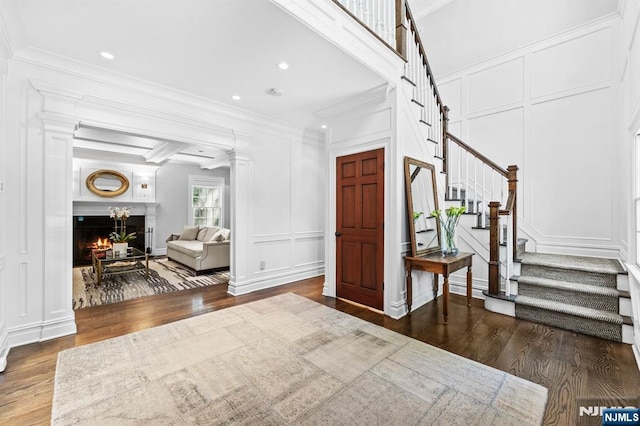 56 Knoll Rd, Tenafly, NJ 07670 - foyer with a decorative wall, wood finished floors, ornamental molding, stairs, and a warm lit fireplace