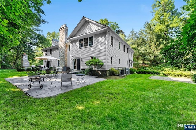 56 Knoll Rd, Tenafly, NJ 07670 - rear view of house featuring a chimney, a yard, a patio area, and central air condition unit
