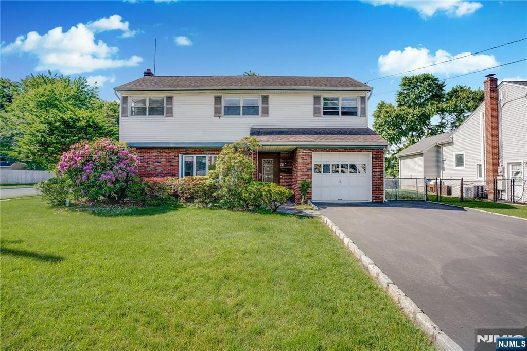 73 White Beeches Dr, Dumont, NJ 07628 - view of front of house with brick siding, asphalt driveway, and an attached garage