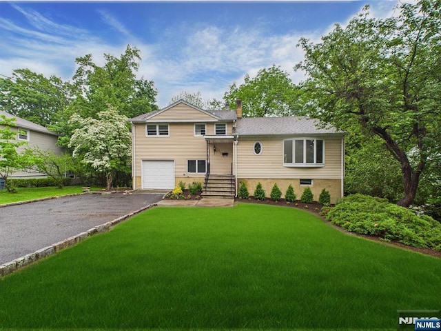 995 Andover Ter, Ridgewood, NJ 07450 - tri-level home featuring asphalt driveway, a garage, a front lawn, and a chimney
