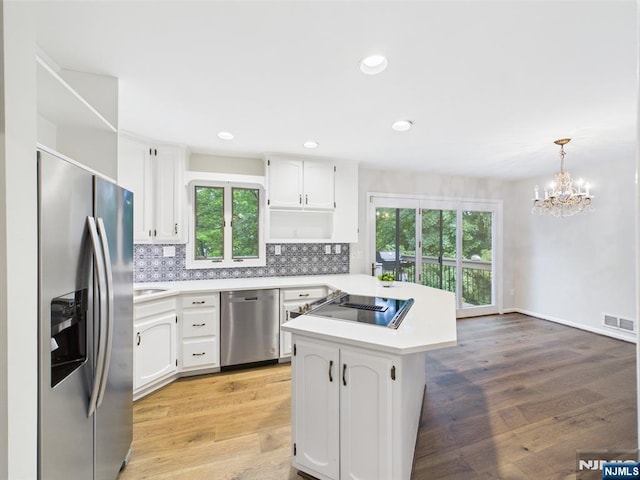 995 Andover Ter, Ridgewood, NJ 07450 - kitchen featuring appliances with stainless steel finishes, open shelves, light countertops, a chandelier, and white cabinets