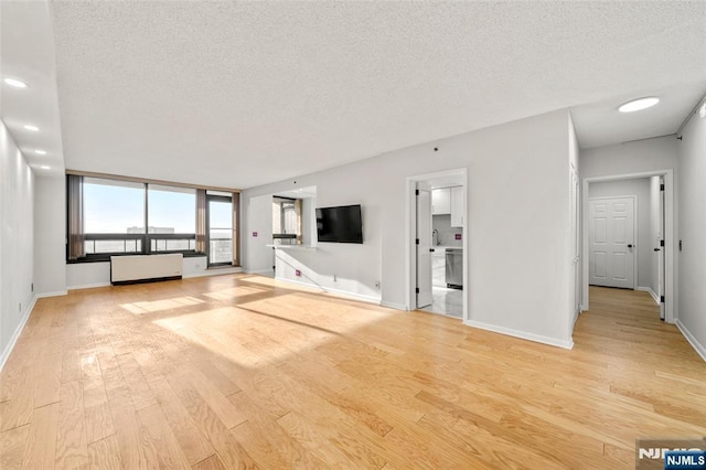 800 Palisade Ave Unit 1804, Fort Lee, NJ 07024 - unfurnished living room featuring a textured ceiling, light wood finished floors, baseboards, a sink, and recessed lighting