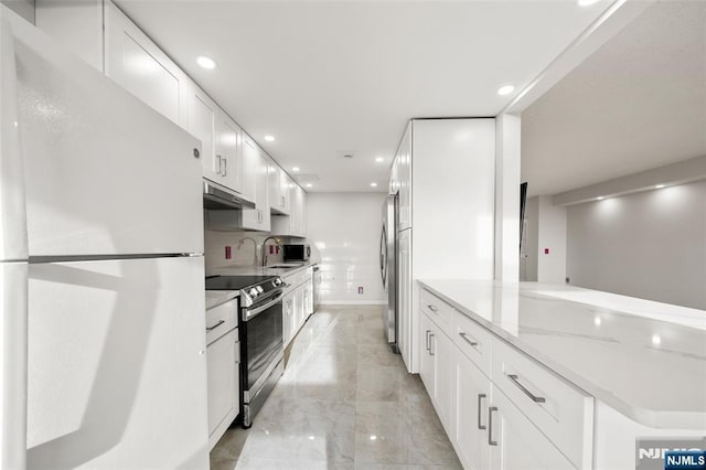 800 Palisade Ave Unit 1804, Fort Lee, NJ 07024 - kitchen featuring appliances with stainless steel finishes, under cabinet range hood, white cabinets, light marble finish floors, and recessed lighting