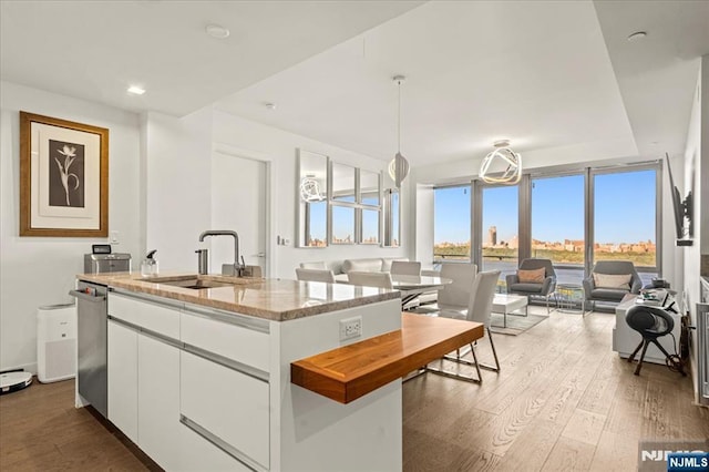 320 Adolphus Ave Unit 317, Cliffside Park, NJ 07010 - kitchen with a sink, white cabinets, wood finished floors, a kitchen island with sink, and light stone counters