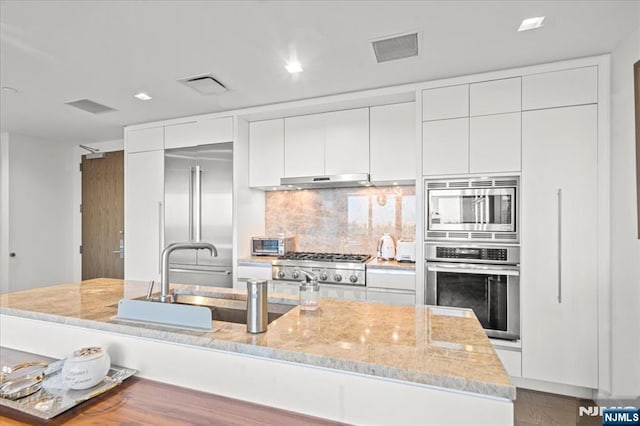 320 Adolphus Ave Unit 317, Cliffside Park, NJ 07010 - kitchen featuring built in appliances, backsplash, white cabinets, and modern cabinets